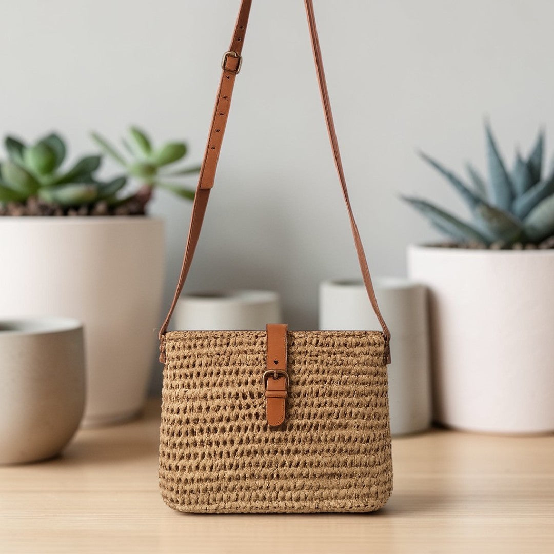 Bolso bandolera artesanal de Commerly con diseño de plantas, hecho a mano en materiales naturales y color neutro.